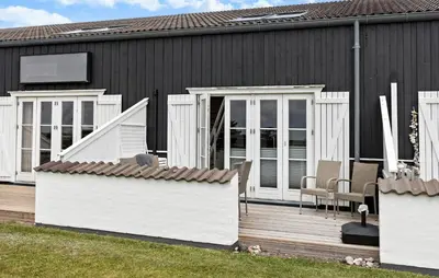 a house with a wooden deck with chairs on it at Stunning Home In Vestervig With Kitchen in Vestervig