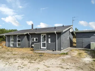 a gray house with a driveway in front of it at Holiday Home Floria - 1-4km from the sea by Interhome in Torsted