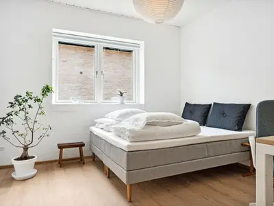 a white bedroom with a bed and a window at Holiday Home Yakari - 1km from the sea by Interhome in Torsted