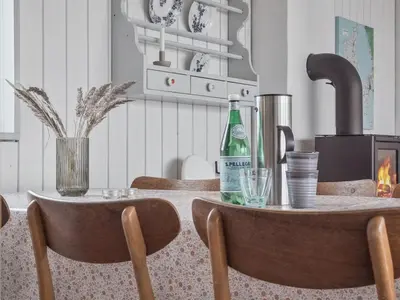 a table with a bottle of wine and two chairs at Holiday Home Werna - 900m from the sea by Interhome in Pandrup