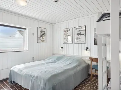 a bedroom with a bed and a desk and a window at Holiday Home Werna - 900m from the sea by Interhome in Pandrup