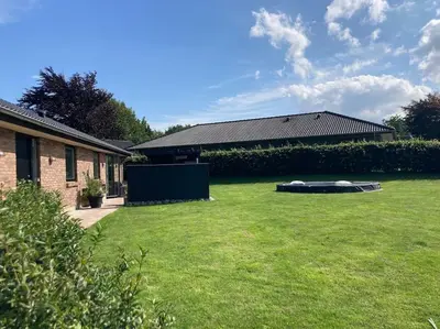 a yard with a house and a large lawn at Hyggeligt hus. in Holstebro