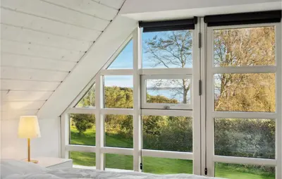 a bedroom with a window looking out at the yard at 3 Bedroom Cozy Home In Løgstrup in Knud