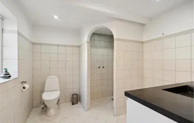 a bathroom with a toilet and a sink at 3 Bedroom Cozy Home In Løgstrup in Knud
