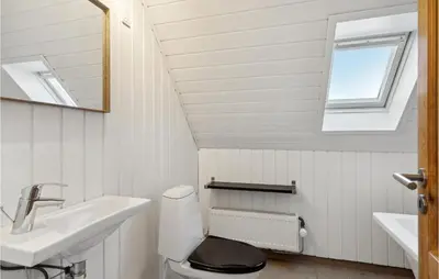 a bathroom with a toilet and a sink and a mirror at 3 Bedroom Cozy Home In Løgstrup in Knud