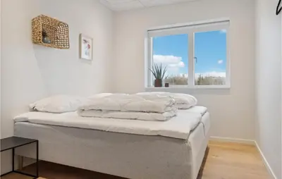 a bedroom with a bed with white walls and a window at Awesome Home In Thisted With Sauna in Thisted