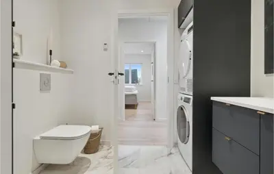 a bathroom with a toilet and a washing machine at Awesome Home In Thisted With Sauna in Thisted