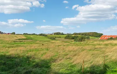 a field of grass with a barn in the distance at Beautiful Home In Nykøbing M With Wifi in Nykøbing Mors