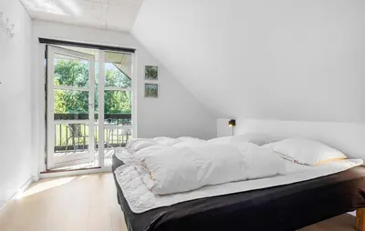 a bedroom with a bed with white sheets and a window at Beautiful Home In Nykøbing M With Wifi in Nykøbing Mors