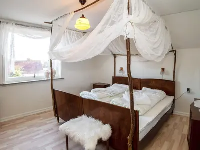 a bedroom with a canopy bed with a white curtain at 8 person holiday home in Lemvig-By Traum in Lemvig