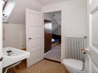 a bathroom with a sink and a toilet and a bedroom at 8 person holiday home in Lemvig-By Traum in Lemvig