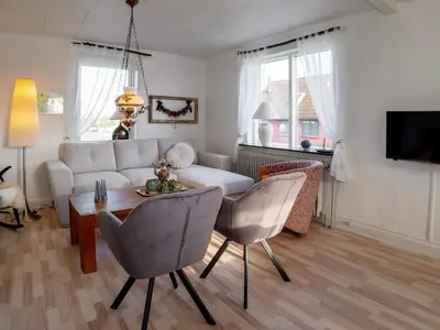 a living room with a couch and a table and chairs at 8 person holiday home in Lemvig-By Traum in Lemvig