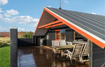 a house with an orange roof with a table and chairs at Nice Home In Harboøre With Wifi in Harboør