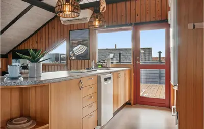 a kitchen with wood paneling and a large window at Nice Home In Harboøre With Wifi in Harboør