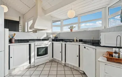 a large kitchen with white cabinets and windows at Pet Friendly Home In Thisted With Wifi in Thisted