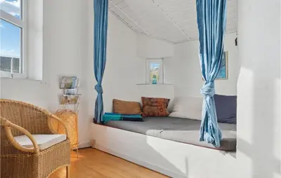 a bed with blue curtains in a white room at Pet Friendly Home In Thisted With Wifi in Thisted