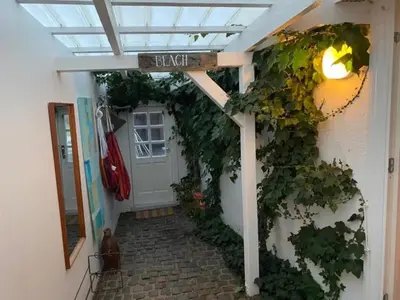 a walkway leading to a door with a sign that reads back at Agger Beach Apartment in Vestervig