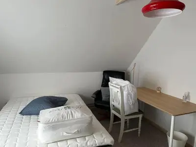 a bedroom with a bed and a desk and a chair at Stor lejlighed ved stranden i Agger Cold Hawaii in Agger