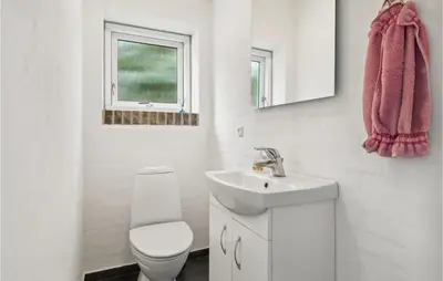 a white bathroom with a toilet and a sink at 3 Bedroom Beautiful Home In Spøttrup in Spottrup