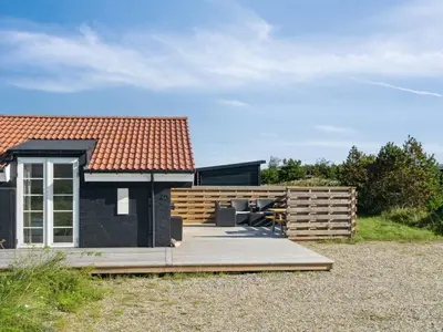 a house with a wooden deck and a fence at Holiday Home Blaguna - 600m from the sea by Interhome in Torsted