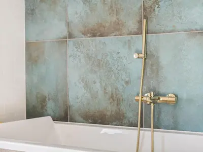 a bathroom with a bath tub with a shower at Holiday Home Blaguna - 600m from the sea by Interhome in Torsted