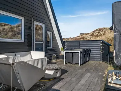 a deck with chairs and a grill on a house at Holiday Home Pauli - 350m from the sea by Interhome in Pandrup