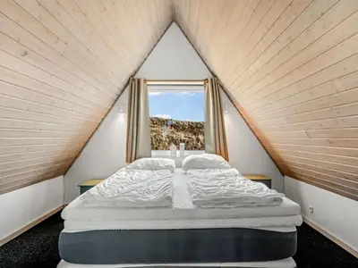 a bed in a small room with a window at Holiday Home Pauli - 350m from the sea by Interhome in Pandrup