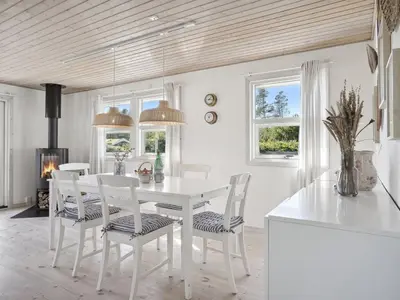 a white dining room with a white table and chairs at Holiday Home Ofelia - 2-5km from the sea by Interhome in Blokhus