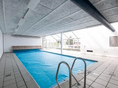 a large indoor swimming pool with blue water at Apartment Virpi - 1km from the sea by Interhome in Blokhus