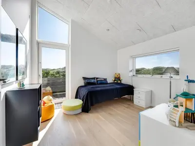 a bedroom with a bed and two windows at Holiday Home Gebko - 150m from the sea by Interhome in Saltum