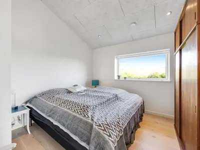 a bedroom with a bed and a window at Holiday Home Gebko - 150m from the sea by Interhome in Saltum