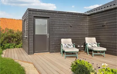 two chairs and a table on a wooden deck at Cozy Home In Lemvig With House Sea View in Lemvig