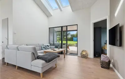 a living room with a couch and a tv at Cozy Home In Lemvig With House Sea View in Lemvig