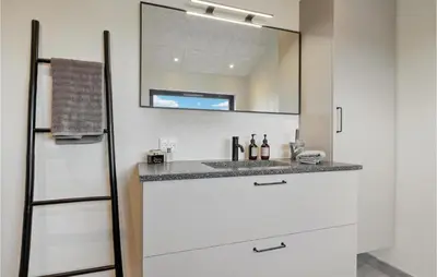 a bathroom with a sink and a mirror at Cozy Home In Lemvig With House Sea View in Lemvig