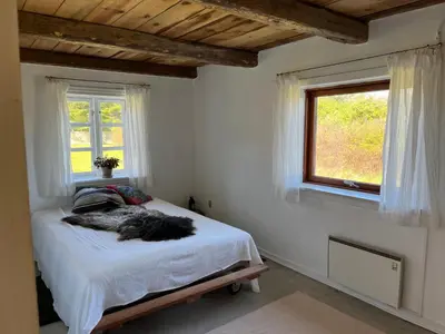 a bedroom with a bed and a window at The Beach Farm - charm, beach and stunning nature in Bedsted Thy