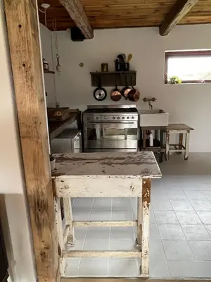 a kitchen with a wooden table and a stove at The Beach Farm - charm, beach and stunning nature in Bedsted Thy
