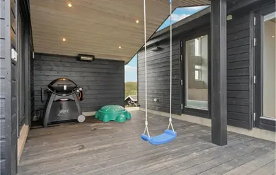 a porch with a swing and a stove at Beautiful Home In Blokhus With Wifi in Blokhus