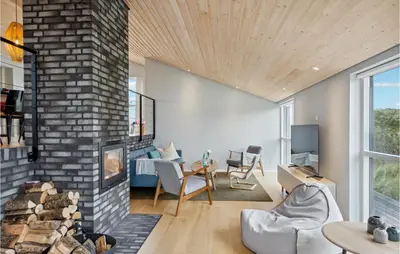 a living room with a fireplace and a brick wall at Beautiful Home In Blokhus With Wifi in Blokhus