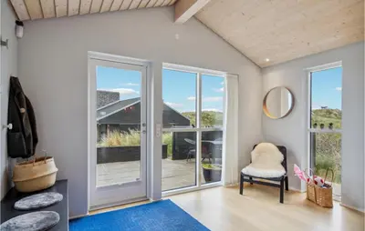 a living room with sliding glass doors and a blue rug at Beautiful Home In Blokhus With Wifi in Blokhus