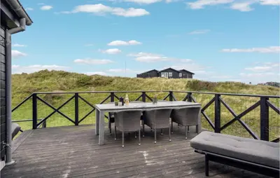 a table and chairs on the deck of a house at Beautiful Home In Blokhus With Wifi in Blokhus