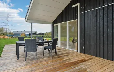 a wooden deck with a black table and chairs at 3 Bedroom Gorgeous Home In Løgstør in Løgsted