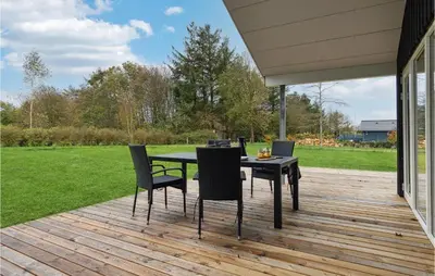 a patio with a table and chairs on a deck at 3 Bedroom Gorgeous Home In Løgstør in Løgsted