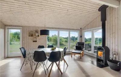 a dining room with a table and chairs and a fireplace at Holiday Home Højslev 42 in Højslev