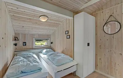 a bedroom with a bed in a room with wooden walls at Holiday Home Højslev 42 in Højslev