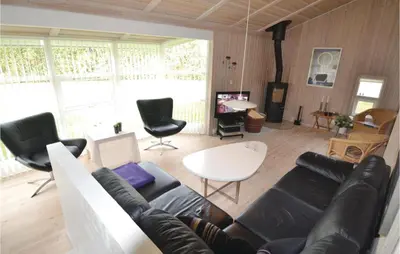 a living room with a black leather couch and chairs at Holiday Home Blokhus 49 in Blokhus