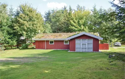 a red house in a yard with a green lawn at Holiday Home Blokhus 58 in Blokhus