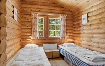 a bedroom with two beds in a log cabin at Holiday Home Blokhus 59 in Blokhus