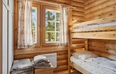 a log cabin bedroom with a bunk bed and a window at Holiday Home Blokhus 59 in Blokhus