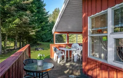 a deck with a table and chairs on a house at Holiday Home Blokhus 9 in Blokhus
