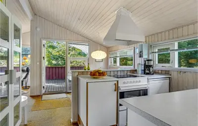 a kitchen with white appliances and windows at Holiday Home Blokhus 9 in Blokhus